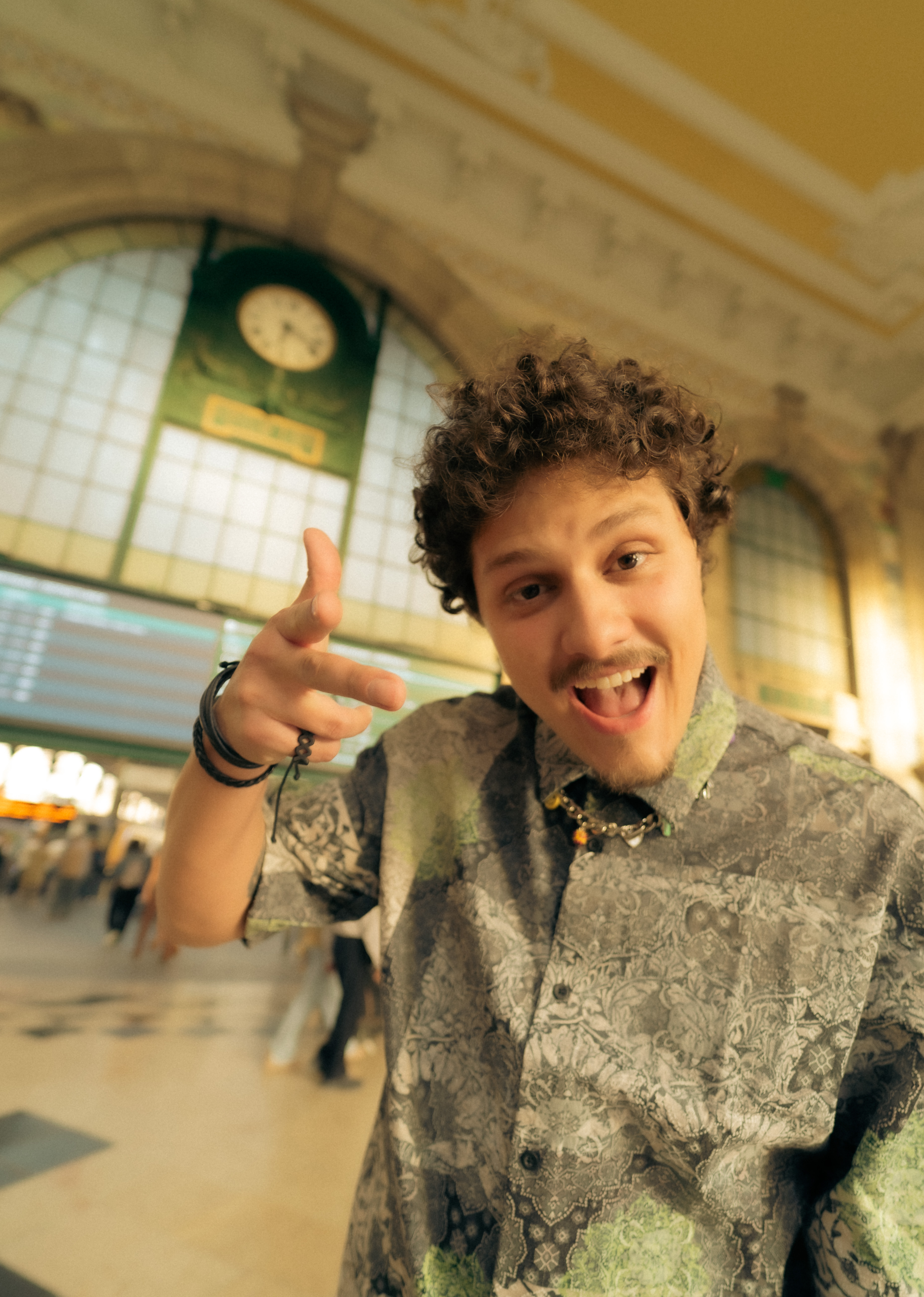 DJ Tilulu apontando para a câmera numa estação antiga