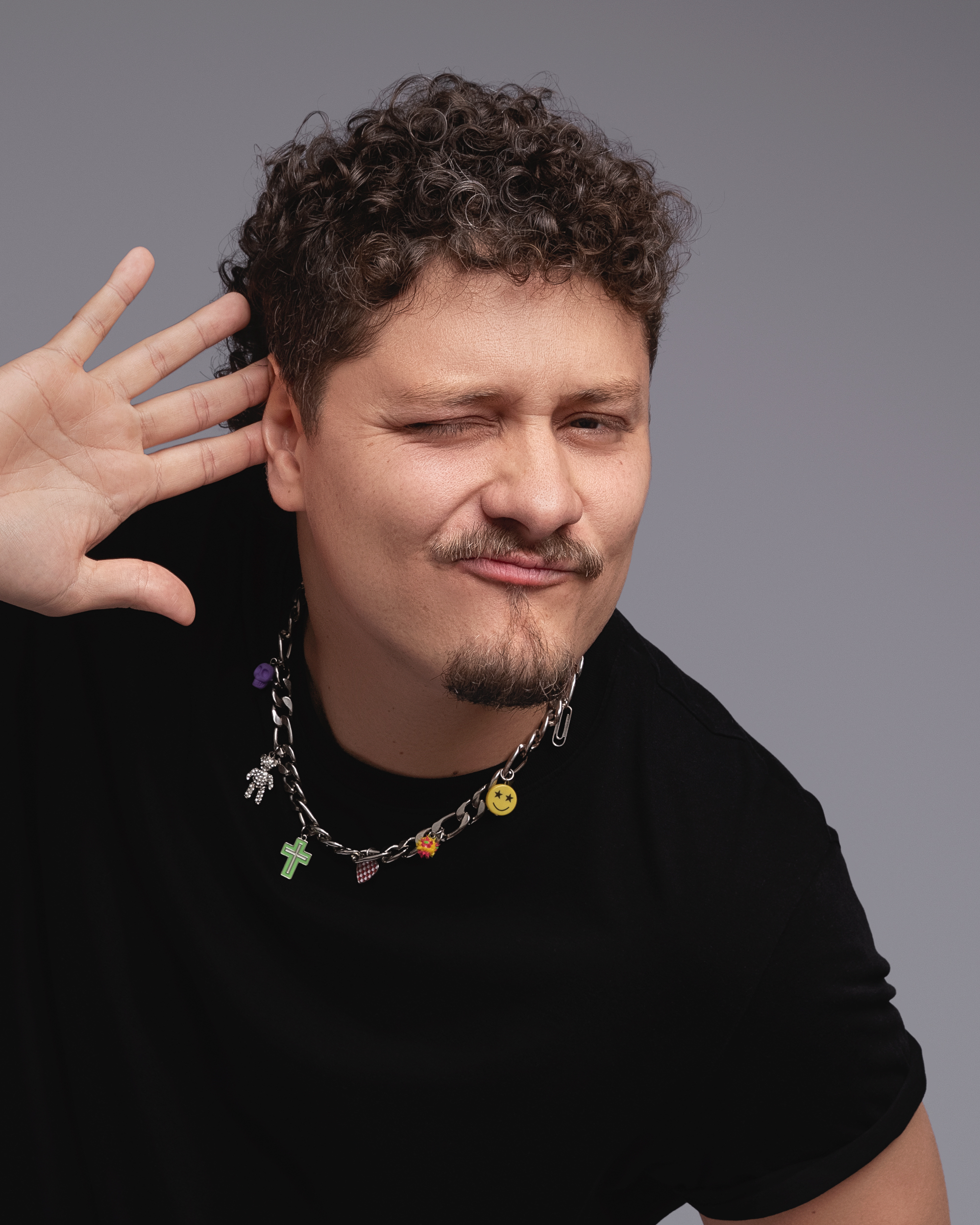 DJ Tilulu piscando, com a mão no ouvido